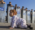 Imaginea zilei: un copilas sirian, in fata cordonului de politie, in Turcia. Sute de refugiati, blocati la granita cu Grecia - VIDEO