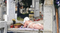 Femeie pozata facand plaja intr-un cimitir din Alba Iulia, pe o piatra de mormant
