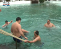 Femei, barbati si copii au sfidat gerul de afara si s-au aruncat de Boboteaza in apa inghetata a unui bazin din curtea manastirii Tiganesti - VIDEO