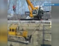 Accident incredibil in Rusia. O macara s-a prabusit peste un buldozer in timp ce incerca sa-l coboare