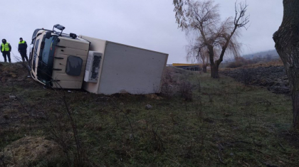 Un sofer al unui autocamion s-a ales cu o sperietura zdravana, dupa ce vehiculul pe care il conducea a derapat si s-a rasturnat