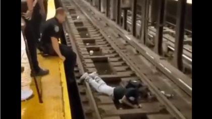 Un politist sare pe sinele de metrou si salveaza un barbat cu doar cateva clipe inainte de venirea trenului in statie Un politist sare pe sinele de metrou si salveaza un barbat cu doar cateva clipe inainte de venirea trenului in statie