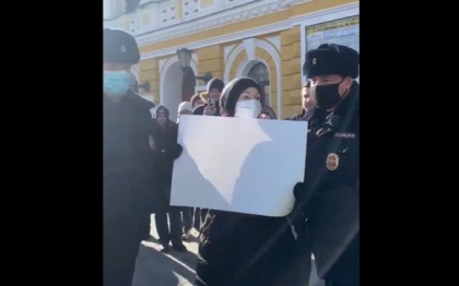 O fata cu pancarta alba in maini, retinuta de politia rusa in timpul protestelor. Moscova reprima dur orice protest impotriva razboiului
