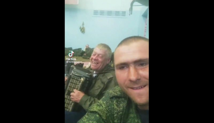 Un soldat rus incearca sa-si binedispuna camarazii cu acordeonul dupa cateva pahare - VIDEO