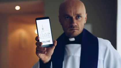 Preotul care sfinteste telefoanele credinciosilor, ca sa-i protejeze de „fake news” si ura din online