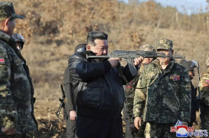 Imbracat in geaca de piele, Kim Jong Un tine strans o arma in umar, in timpul unei inspectii la o importanta baza de antrenament Imbracat in geaca de piele, Kim Jong Un tine strans o arma in umar, in timpul unei inspectii la o importanta baza de antrenament