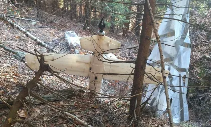 Dronă care are agățată o paraşută