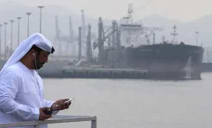 Un bărbat pozează în fața unei nave petroliere de la terminalul Fujairah din Emiratele Arabe Unite Un bărbat pozează în fața unei nave petroliere de la terminalul Fujairah din Emiratele Arabe Unite