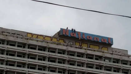 Distractie periculoasa la inaltime: Cativa oameni si-au riscat viata plimbandu-se agatandu-se de literele hotelului National - FOTO