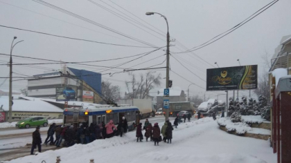 Un troleibuz, impins de pasageri pe o strada din capitala. A oprit in statie si nu s-a mai putut urni din loc din cauza ninsorii - GALERIE FOTO
