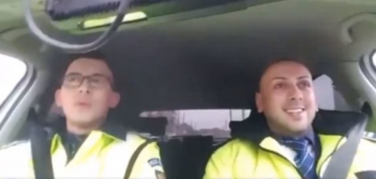 Viral pe Facebook. Un politist din Romania canta " Mos Craciun cu plete dalbe" in masina - VIDEO