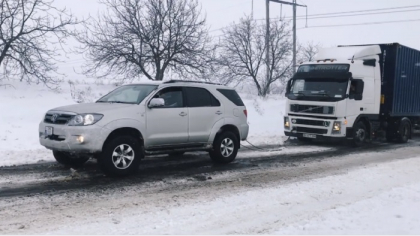 Acolo unde n-au ajuns pompierii, soferii s-au ajutat unii pe altii. Momentul in care un barbat incearca sa scoata din zapada mai multe vehicule, printre care si un TIR - VIDEO