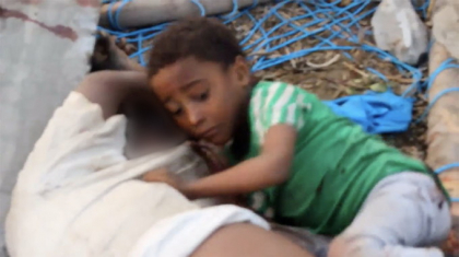 Baietel agatat de trupul tatalui mort dupa bombardament, imagine puternica a razboiului din Yemen - VIDEO