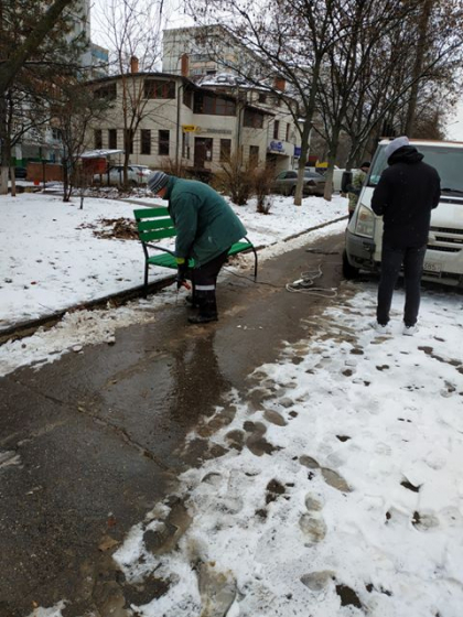 Mai multi muncitori, pusi pe treaba: instaleaza banci si le dau cu vopsea in timp ce afara cade lapovita - GALERIE FOTO