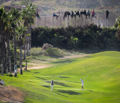 Ciocnirea "civilizatiilor". Zeci de imigranti cocotati pe un gard de granita, langa un teren de golf: imaginea ajunsa virala