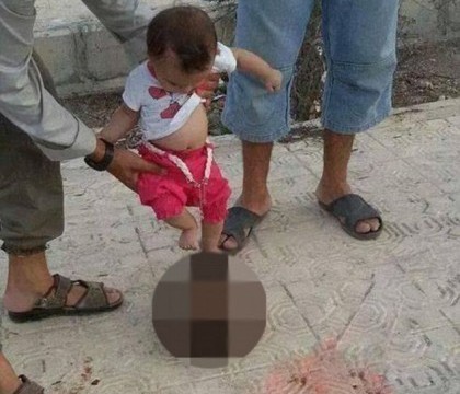 Imagini groaznice din interiorul Statului Islamic. Un bebelus este indemnat sa loveasca capul taiat al unui soldat sirian Imagini groaznice din interiorul Statului Islamic. Un bebelus este indemnat sa loveasca capul taiat al unui soldat sirian