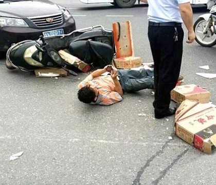 Moment absurd. Un motociclist a continuat sa se joace pe telefon desi fusese accidentat si era ranit pe sosea. FOTO