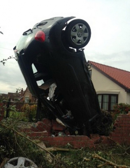O masina a ramas in pozitie verticala in urma unui accident, dupa ce soferita a trecut cu roata peste o groapa. FOTO O masina a ramas in pozitie verticala in urma unui accident, dupa ce soferita a trecut cu roata peste o groapa. FOTO