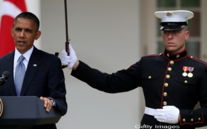 Presedintele Barack Obama, in atentia presei dupa ce a pus un puscas marin sa-i tina o umbrela Presedintele Barack Obama, in atentia presei dupa ce a pus un puscas marin sa-i tina o umbrela