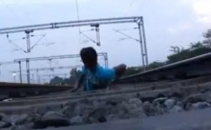 Moartea, luata in ras. Sta intins pe sine in timp ce trenul trece peste el. VIDEO sinonim cu nebunia