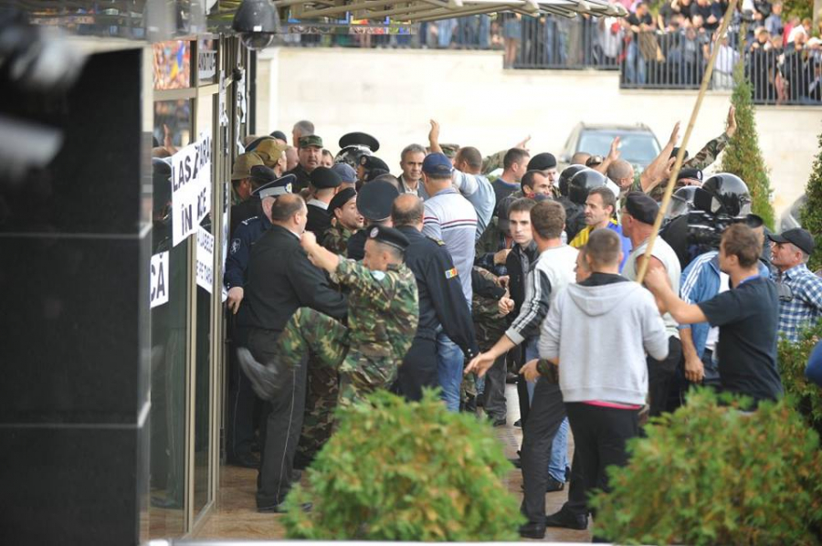 GALERIE FOTO: Atmosfera EXPLOZIVA - Sute de protestatari la sediul atribuit firmelor lui Plahotniuc. Imbranceli si spargerea cordonului de politisti