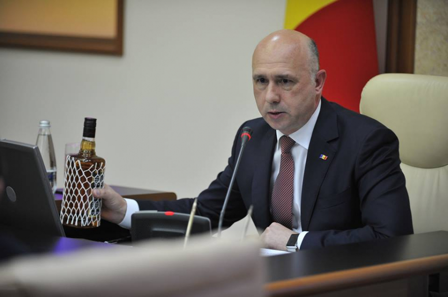 Motivul pentru care premierul Pavel Filip a venit cu o sticla de whisky la sedinta de guvern de astazi. Ar fi cumparat-o de pe un site de anunturi - GALERIE FOTO