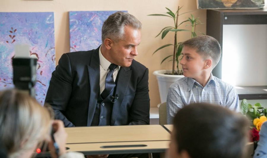 Vlad Plahotniuc, cu lavaliera la ceremonia de 1 septembrie din satul sau natal. Liderul PD a publicat pe internet fotografii, unde in timp ce vorbeste cu picii, un microfon ii sta agatat de sacou - FOTO